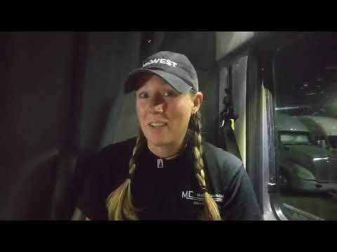 Female truck driver smiling in truck cab