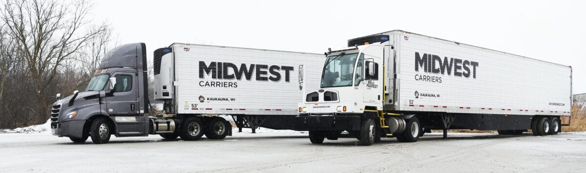 Two Midwest Carriers trucks parked side by side in winter