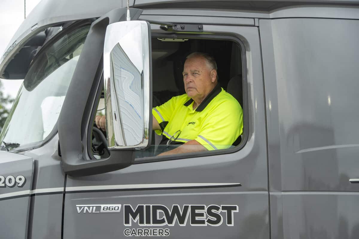 Truck driver sitting in cab of Midwest Carriers truck