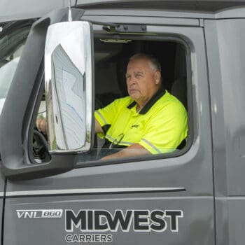 Truck driver sitting in cab of Midwest Carriers truck