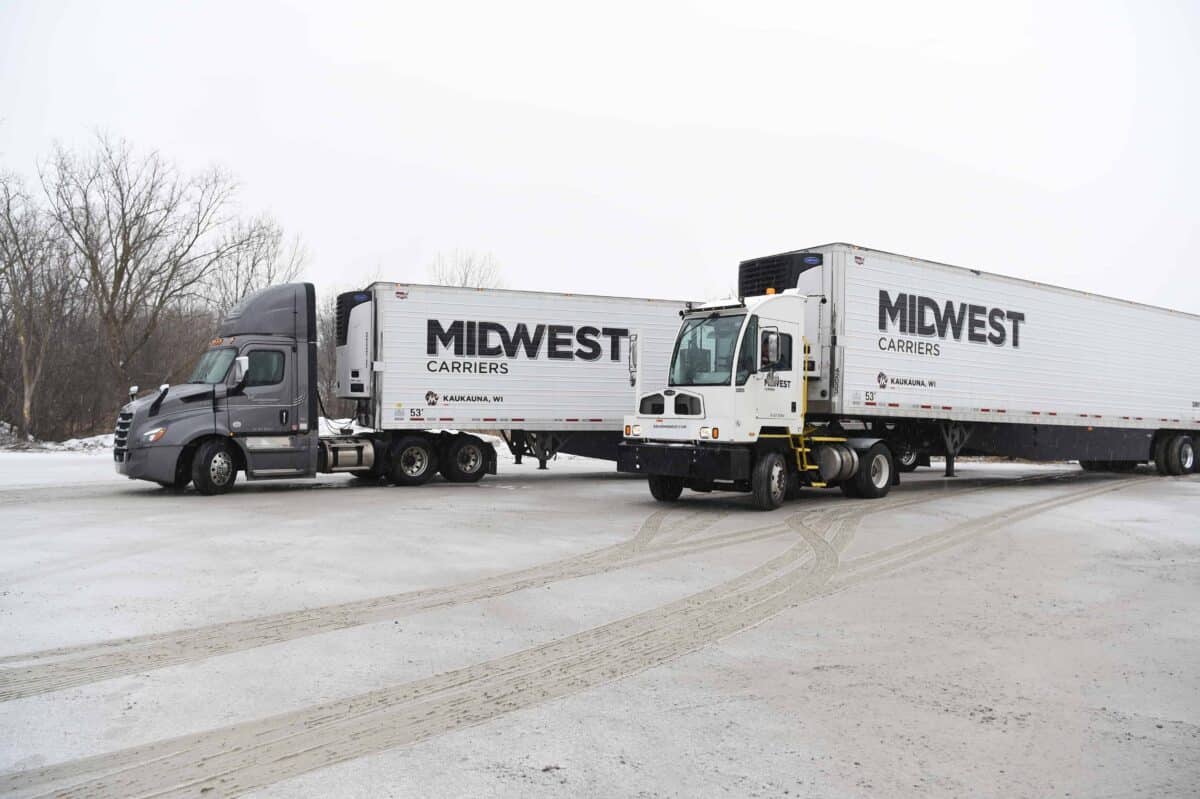 Two Midwest Carriers Trucks parked in the winter