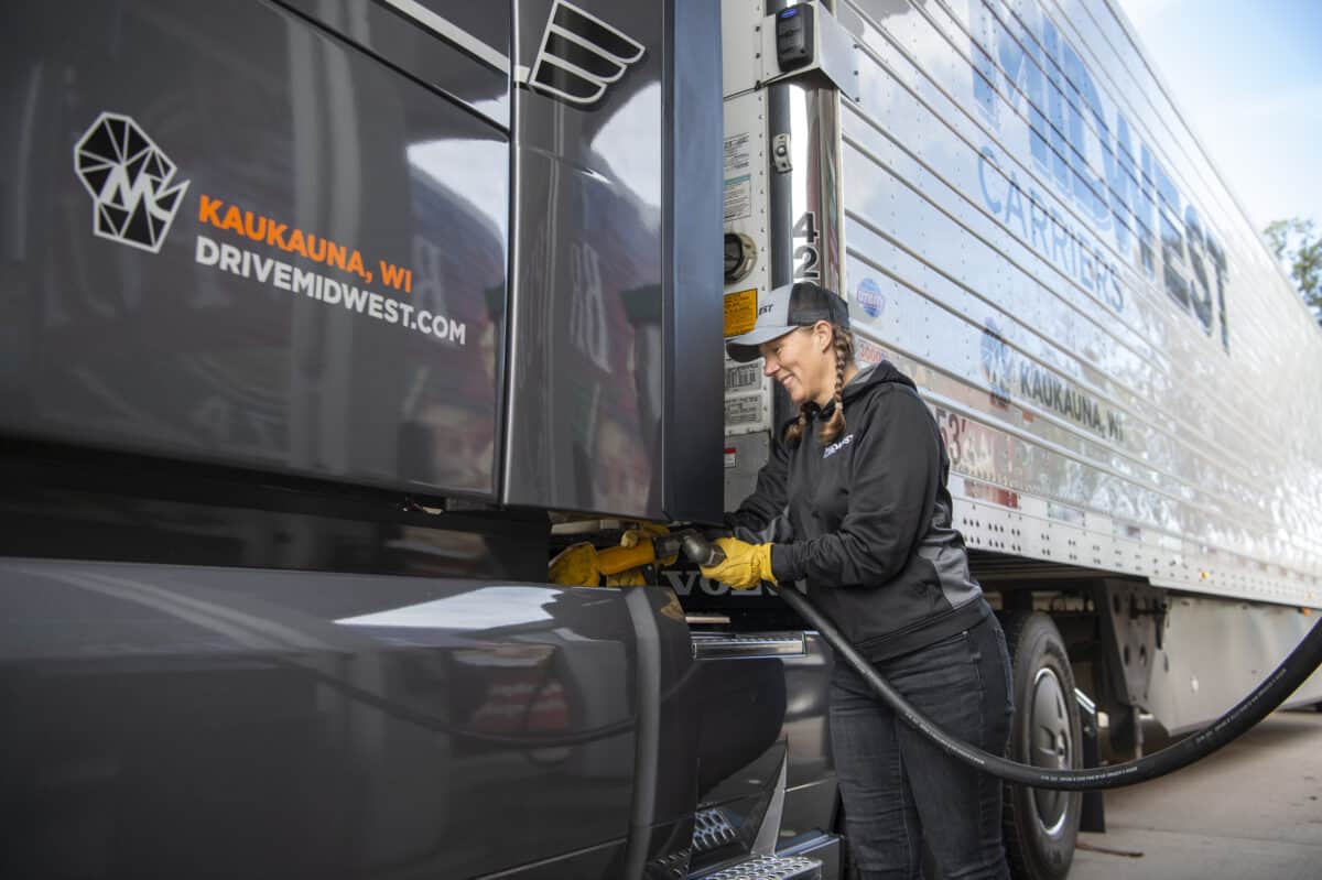 Female truck driver fills the fuel tank of a Midwest Carriers truck