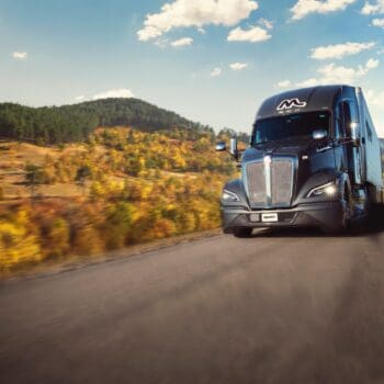 Midwest Carriers truck driving down the road through fall colors
