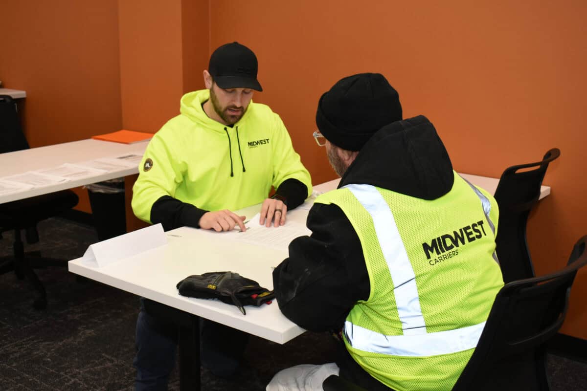 A Midwest Employee explains driver benefits to a new driver in orientation